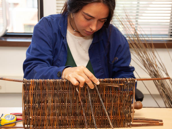 An NBO member weaving a basket